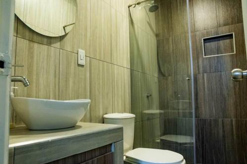La salle de bains est pourvue d'un lavabo, de toilettes et d'une douche. dans l'établissement Cabaña Familiar/La jagua Huila/Piscina y BBQ, à Garzón