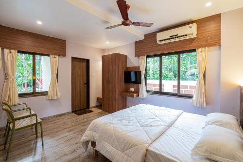 a bedroom with a bed and a ceiling fan at Beach Heaven Villa, Nandgaon in Murud
