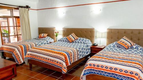 a bedroom with two beds and a window at posada el castellano in Comitán