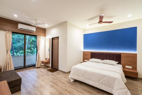a bedroom with a bed and a large window at Beach Heaven Villa, Nandgaon in Murud
