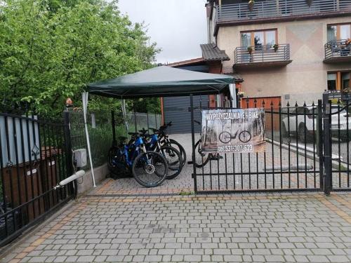 a group of bikes parked under a tent next to a fence at Jodłowa Chata in Myślenice