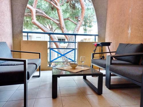 une chambre avec deux chaises, une table et une fenêtre dans l'établissement Port Fréjus - Tout à pied - WIFI - Clim, à Fréjus