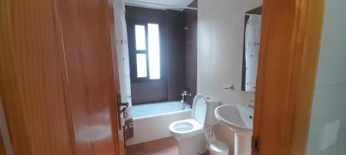 a bathroom with a white toilet and a sink at VFT Castillo de la Yedra in Cazorla
