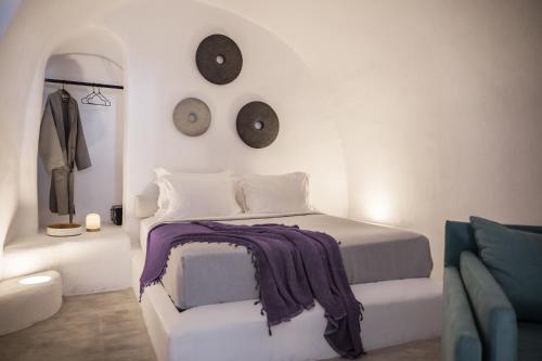 a bedroom with a bed and two clocks on the wall at Yposkafon Concept Villa in Megalochori