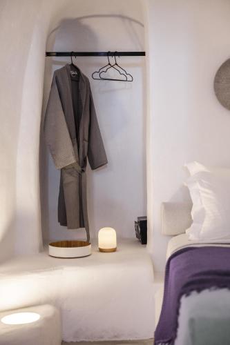 a suit hanging on a rack next to a bed at Yposkafon Concept Two-Bedroom Villa with Private Jacuzzi and Hamam in Megalokhori