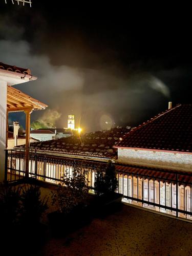 a night view of a house with a fence at Διαμέρισμα center in Arachova