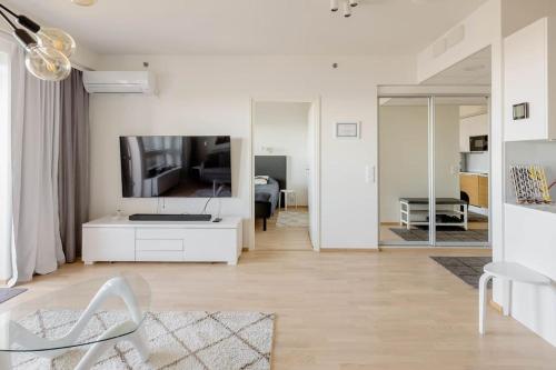 a white living room with a white couch and a tv at Tampere City view near Nokia Arena AC in Tampere