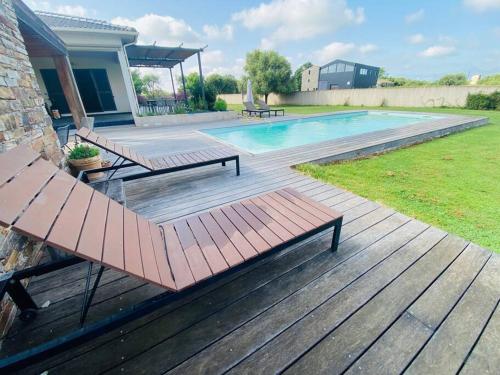 a deck with a bench and a swimming pool at "Villa I Rottani" Magnifique villa avec piscine privée in Aléria