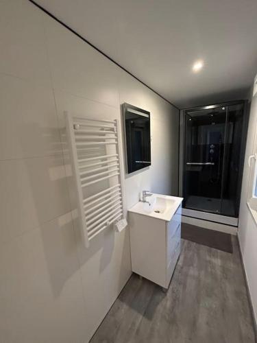 uma casa de banho branca com um lavatório e uma janela em Au Petit Faubourg em Roye