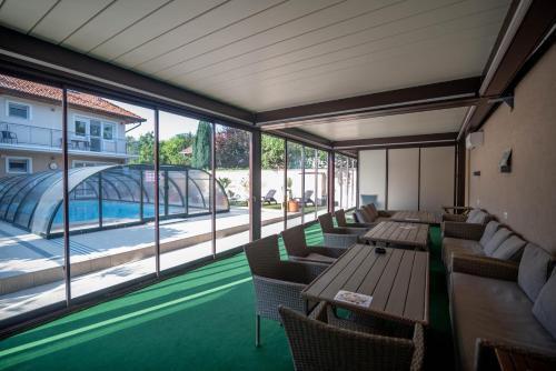 un restaurante con mesas y sillas y vistas a la piscina en Happy Apartments, en Balatonlelle
