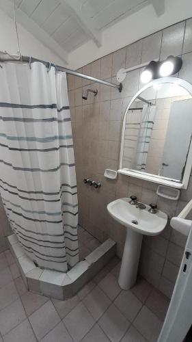 y baño con ducha, aseo y espejo. en Casa Azul a 5 cuadras del centro ya 8 del mar en Villa Gesell