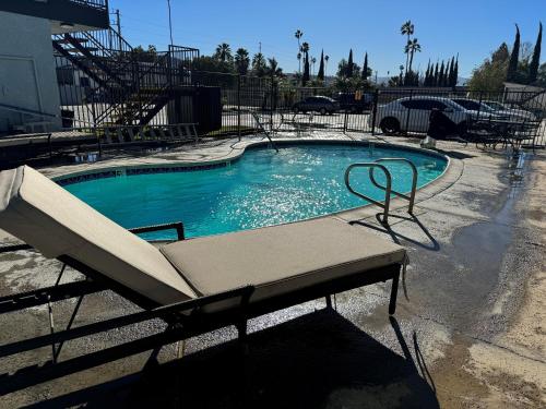 a swimming pool with a chair in front of it at Sands Motel in Riverside
