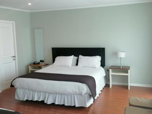 a bedroom with a large bed with a black headboard at Hotel Del Rio in Constitución