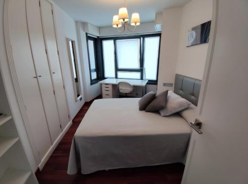 1 dormitorio con 1 cama, escritorio y ventanas en Apartamento ANA - 1 Habitación en A Coruña