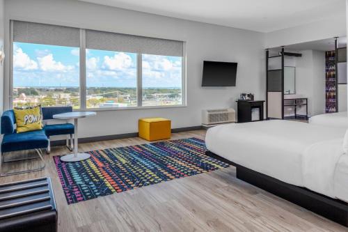 um quarto de hotel com uma cama, uma secretária e uma televisão em Aloft Dallas Arlington South em Arlington