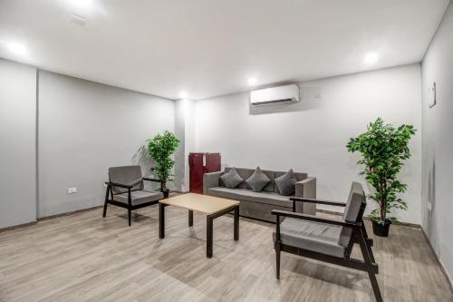 a living room with a couch and a table and chairs at Super Townhouse RCC Majestic 397 LB Nagar in Hyderabad