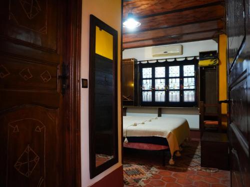 a bedroom with a bed and a window in a room at La Kasbah Elkhorbat Muxu Berbere in Asrir