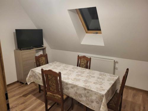 a dining room with a table and a television at Agroturystyka nad Stawem in Miedzygorze