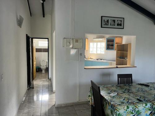 1 dormitorio con 1 cama, cocina y pasillo en haut de villa spacieux et calme, en Morne-à-lʼEau