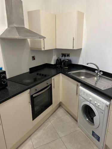 una cucina con lavandino e lavatrice di Modern 1 bed apartment in Salford a Manchester