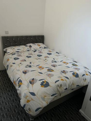 1 cama con edredón de flores en un dormitorio en Modern 1 bed apartment in Salford en Mánchester