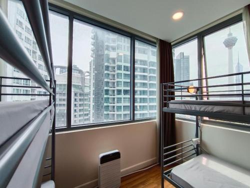 a bedroom with two bunk beds in a building with windows at KLCC Dorm (7 min walking to Twin Towers) in Kuala Lumpur