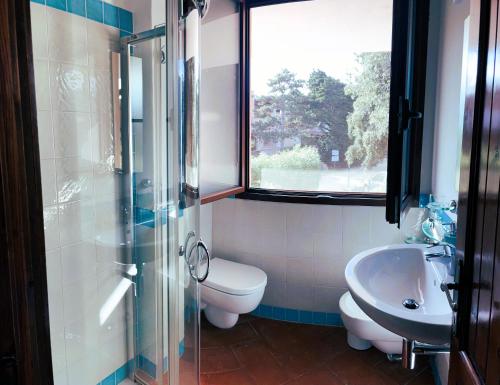 a bathroom with a toilet and a sink and a window at Splendida vista mare zona centrale Porto Rotondo posto auto privato in Porto Rotondo