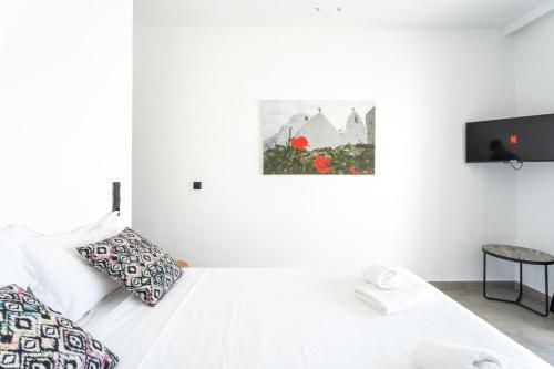 a white room with a bed and a tv at BLUE WATERS MYKONOS in Ornos