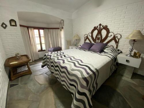 een slaapkamer met een groot bed met paarse kussens bij Aku Aku in Punta del Este