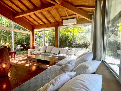 uma sala de estar com sofás brancos e uma grande janela em Gîte familial en pleine nature- Domaine Temali em Labouheyre