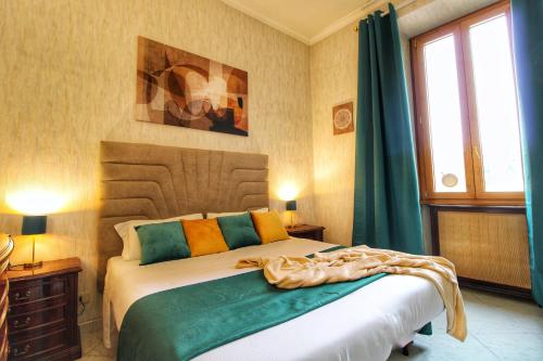 - une chambre avec un lit doté d'oreillers vert et orange dans l'établissement Garibaldi Apartment in Trastevere By YourHost, à Rome