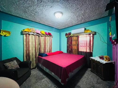 a bedroom with a pink bed and a couch at Agradable casa de 4 habitaciones 2 baños cómodos in La Ceiba