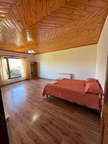 a bedroom with a bed and a wooden ceiling at Casa 48 in El Calafate