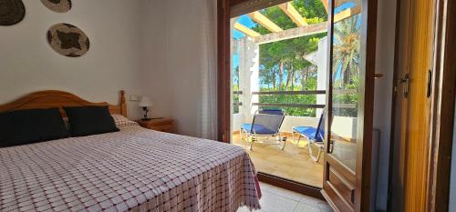 a bedroom with a bed and a door to a patio at Casa Miami Playa in Miami Platja