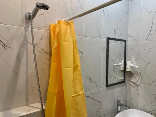 a shower curtain is hanging in a bathroom at Podolski Hostel in Kyiv