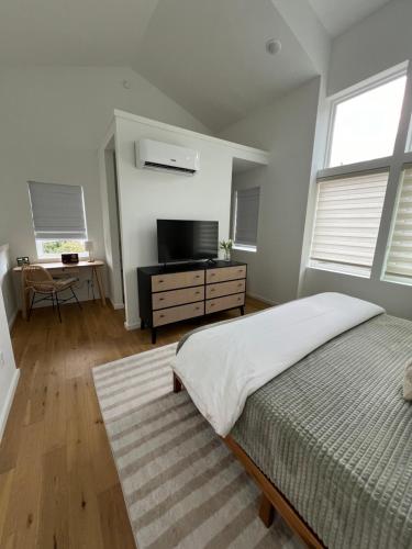 1 dormitorio con 1 cama y TV de pantalla plana en Centrally located modern townhome free parking, en Chattanooga