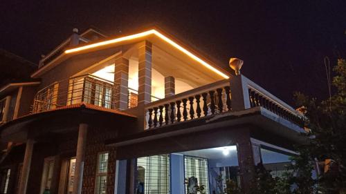 een groot huis met een balkon in de nacht bij Dinoos Sea View in Malvan