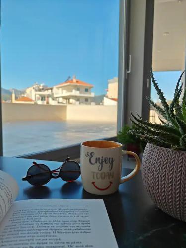 a coffee cup with glasses and a book on a table at Orchidea Flat in Tripolis
