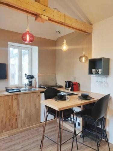 cocina con mesa de madera y 2 sillas en Adorable maisonnette proche Fontainebleau/Barbizon en Chailly-en-Bière