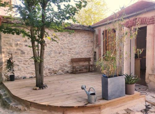 une terrasse en bois avec un arbre et un banc dans l'établissement Adorable maisonnette proche Fontainebleau/Barbizon, à Chailly-en-Bière