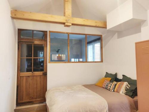 1 dormitorio con cama y ventana en Adorable maisonnette proche Fontainebleau/Barbizon, en Chailly-en-Bière