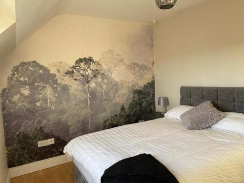 a bedroom with a large mural of trees on the wall at LOCH CONNELL LODGE rooms 1 2 3 4 5 in Letterkenny