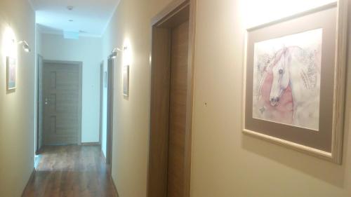 a hallway with a painting of a horse on the wall at Villa Cheval in Aukštadvaris