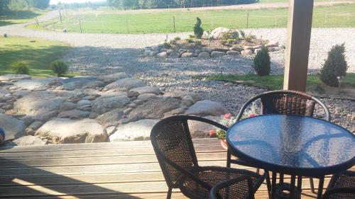 a table and chairs on a porch with a rock garden at Villa Cheval in Aukštadvaris