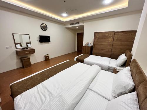 a hotel room with two beds and a tv at Soulmate Hotel Erbil in Erbil