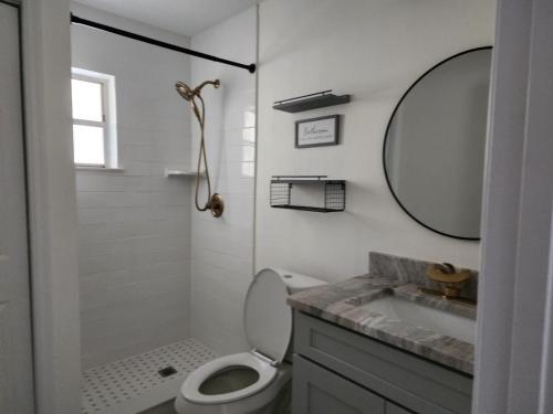 a bathroom with a toilet and a sink and a mirror at Studio furnished in Kissimmee