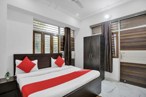 1 dormitorio con 1 cama con almohadas rojas y blancas en Krishna Palace, en Vrindāvan