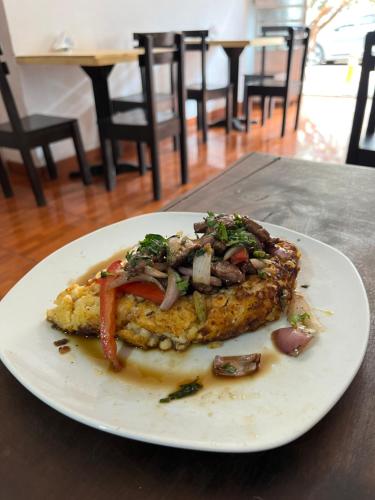 a white plate with a piece of food on a table at Cusco House Inn Hostel in Cusco