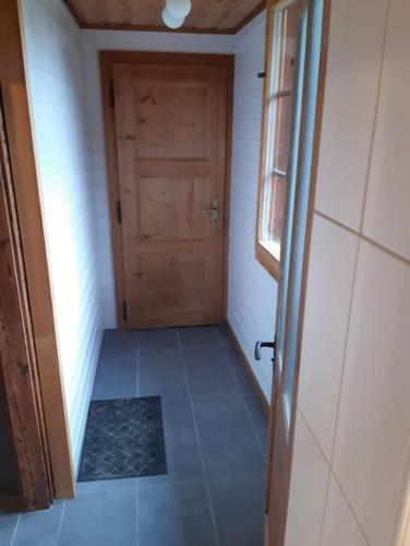 an empty hallway with a door and a tile floor at Charme et authenticité in Evolène