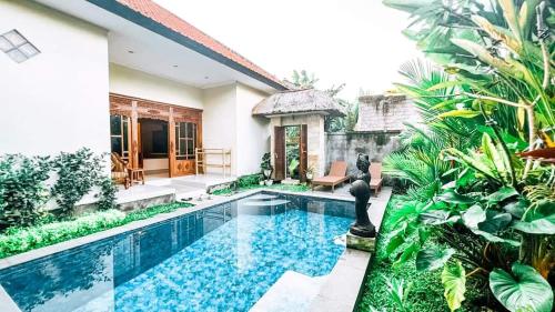 uma villa com uma piscina num jardim em Private Villa 2 bedrooms with private pool em Ubud